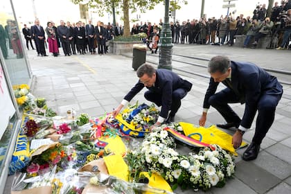 El primer ministro sueco Ulf Kristersson y su homólogo belga Alexander De Croo, colocan una corona de flores y una camiseta de la selección de fútbol de Suecia durante un acto de homenaje a las víctimas de un tiroteo en Bruselas