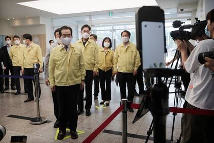 El primer ministro surcoreano, Chung Sye-kyun, quinto desde la izquierda, se verificará la temperatura de su cuerpo a su llegada a una academia educativa privada para verificar las medidas de prevención del nuevo coronavirus en Seúl