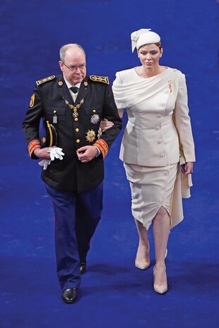 El príncipe Alberto de Mónaco con su mujer, Charlene, que lució un conjunto de chaqueta y falda y una capa.
