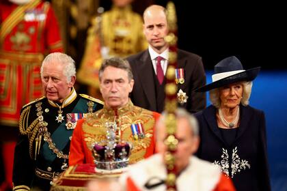 El Príncipe Carlos de Inglaterra, Camilla, Duquesa de Cornualles y el Príncipe Guillermo, Duque de Cambridge, pasan por la Galería Real durante la Apertura de Estado del Parlamento, en Londres, el 10 de mayo de 2022. 