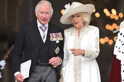 El príncipe Carlos y la duquesa de Cornwall, con vestido blanco con detalles bordados en dorado y sombrero de flores.