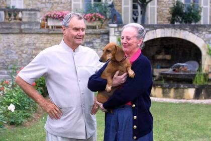 El príncipe Enrique y la reina Margarita II de Dinamarca junto a uno de sus perros salchicha