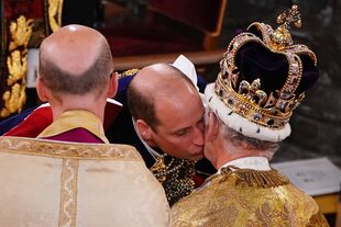 El príncipe Guillermo de Gales besa a su padre, el rey Carlos III, con la corona de San Eduardo, durante la ceremonia de coronación del rey en la abadía de Westminster, en el centro de Londres, el 6 de mayo de 2023. 