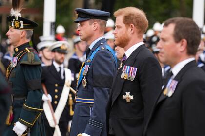  El Príncipe Guillermo de Inglaterra, Príncipe de Gales y el Príncipe Harry de Inglaterra, Duque de Sussex siguen a un grupo de portadores de la Compañía de la Reina, 1er Batallón de Guardias de Granaderos que llevan el féretro de la Reina Isabel II fuera de la Abadía de Westminster en Londres el 19 de septiembre de 2022, antes del Servicio Funeral de Estado.