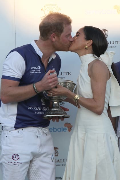 El príncipe Harry le puso el broche de oro a su victoria dándole un romántico beso a su mujer en el podio.