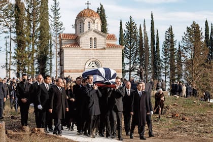 El príncipe heredero Pablo y sus hermanos, los príncipes Nicolás y Philippos, cargan en hombros el féretro hacia su destino final.