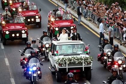 El príncipe Hussein y la saudita Rajqa Alseif saludan a sus seguidores camino a la ceremonia