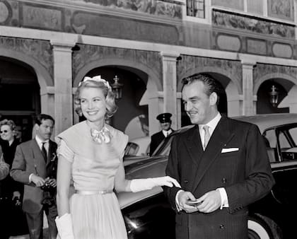 El príncipe Raniero III y su futura mujer saludan a los simpatizantes en el patio de palacio antes de su boda civil, el día anterior