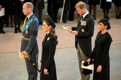 El príncipe William, a la izquierda, Kate, princesa de Gales, segunda a la izquierda, el príncipe Harry y su esposa Meghan, la duquesa de Sussex, a la derecha, presentan sus respetos a la reina Isabel II mientras el ataúd descansa en Westminster Hall para su estado acostado, en Londres, el 14 de septiembre de 2022 (Christopher Furlong/Pool Photo via AP)