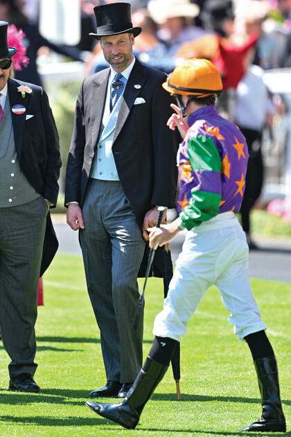 El príncipe William conversa con uno de los jockeys que participó de las carreras del miércoles 18.
