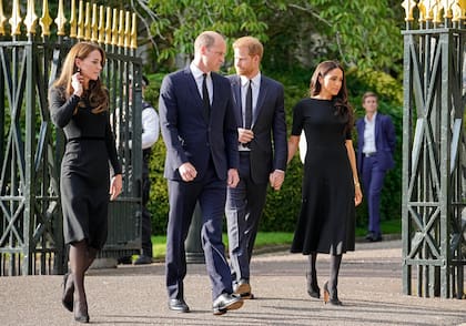 El príncipe William, segundo a la izquierda, y Kate, princesa de Gales, a la izquierda, y el príncipe Harry, segundo a la derecha, y Meghan, duquesa de Sussex, salen de la puerta para ver los tributos florales para la difunta reina Isabel II fuera del Castillo de Windsor, en Windsor, Inglaterra, sábado 10 de septiembre de 2022 (Foto AP/Martin Meissner)
