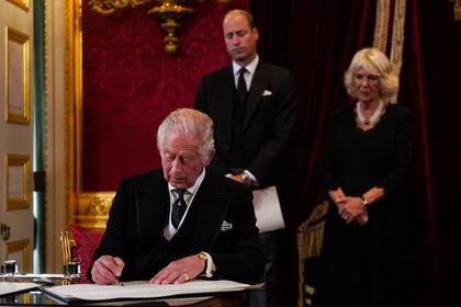 El Príncipe William y Camilla, la Reina Consorte, observan cómo el Rey Carlos III de Gran Bretaña firma un juramento para defender la seguridad de la Iglesia en Escocia, durante una reunión del Consejo de Adhesión dentro de St James's Palace