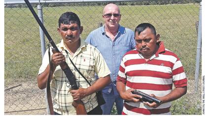 El productor arrocero Juan Martín Pérez, entre dos guardias, en su plantación en el estado Portuguesa.