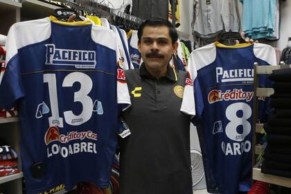 El propietario de la tienda, Jorge Becerras, muestra sus camisetas del club de fútbol Dorados en venta en Culiacán, estado de Sinaloa, México