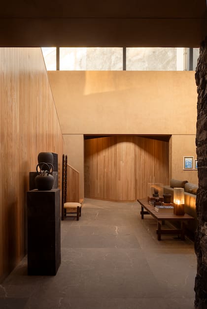 El proyecto se organiza en dos crujías vinculadas por un jardín central: una destinada a los espacios privados y otra que reúne las áreas sociales, prolongadas bajo un pórtico en voladizo. Los pisos están revestidos en porcelanato.