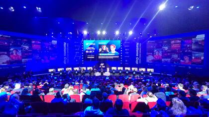 El público asistiendo a la final de la copa mundial de Gran Turismo 7; los pilotos están sentados en los simuladores al fondo de la imagen