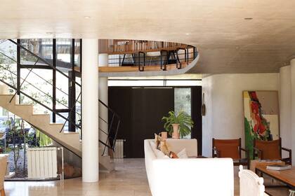 El pulmón circular de aire y luz natural es el corazón de la casa y el que organiza los espacios. En el living conviven esculturas y pinturas de su mamá con muebles vintage heredados de su abuela