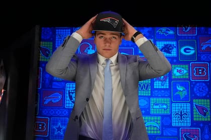 El quarterback Drake Maye se coloca la gorra en la cabeza después de que lo eligieron los Patriots de Nueva Inglaterra con la tercera selección del Draft de la NFL