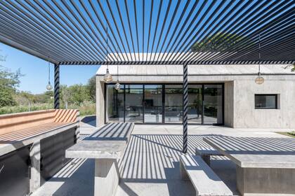 El quincho abierto se une visualmente a la casa al ser también de hormigón. Tiene una estructura de caño (Estudio Bronce) por la que empieza a trepar una glicina.