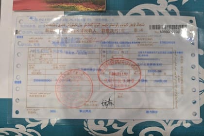 El recibo de una multa de 2600 dólares impuesta a Zumret Dawut, una mujer uigur de la región occidental de Xinjiang de China, por tener demasiados hijos.