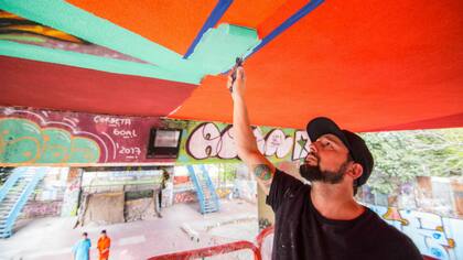 El reconocido artista Martín Ron en acción, bajo el puente 14 de Agosto