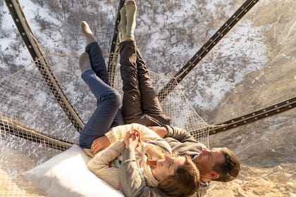 El reflejo del sol al atardecer pinta la montaña de tonos dorados, mientras que las cápsulas se iluminan como pequeñas joyas incrustadas en la roca