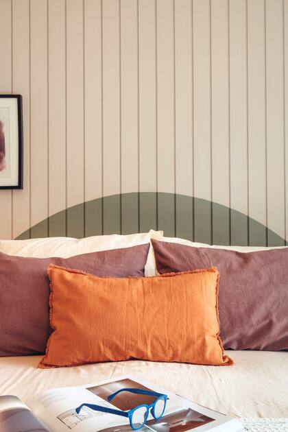 El respaldo de cama semicircular pintado genera un atractivo visual y combina con el color de la ropa de cama hecha en tusor y teñida artesanalmente.