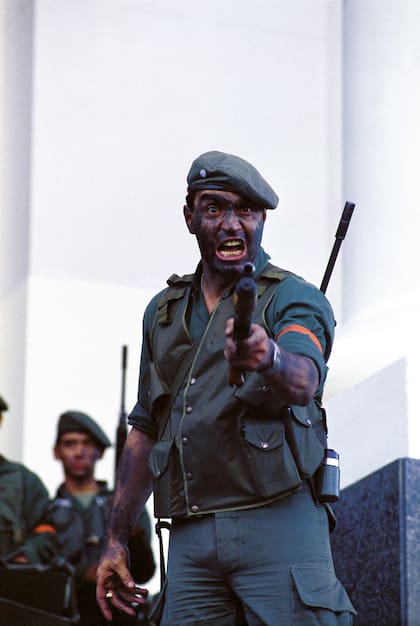 El retrato del sargento Guillermo Daniel Verdes apuntando con su arma a los periodistas que se reunieron frente al Edificio Libertador se convirtió en la imagen emblemática de la rebelión carapintada del 3 de diciembre de 1990. Horas más tarde, Verdes sería asesinado por un francotirador. (Photo by Ricardo Ceppi/Getty Images)