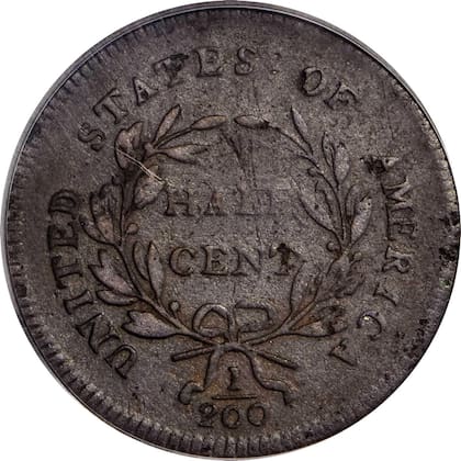 El reverso de esta moneda muestra cinco bayas en la rama izquierda de la corona y cuatro en la derecha