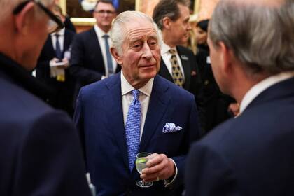 El rey Carlos III de Gran Bretaña recibe a los invitados mientras hospeda una recepción en el Palacio de Buckingham, en el centro de Londres, el 27 de noviembre de 2023.