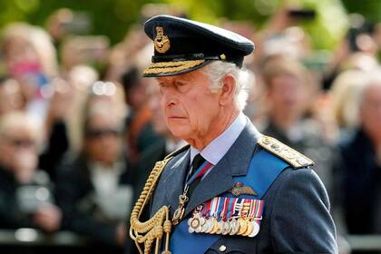 El rey Carlos III de Gran Bretaña sigue el ataúd de la reina Isabel II, adornado con un estandarte real y la corona del estado imperial y tirado por un carro de armas de la artillería a caballo real de la tropa del rey, durante una procesión desde el Palacio de Buckingham hasta el Palacio de Westminster. en Londres el 14 de septiembre de 2022