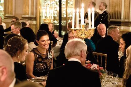 El Rey (de espaldas) y su hija y heredera del trono, Victoria (de frente), durante el banquete.
