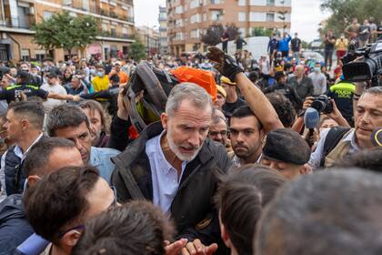 El rey Felipe VI de España habla con sobrevivientes de las inundaciones en España en un ambiente tenso, el domingo 3 de noviembre de 2024, en Paiporta, cerca de Valencia, España. (AP Foto/David Melero)