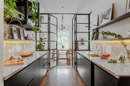 El riel de luces del comedor marca el eje que va de la fachada a la cocina llevando claridad hasta el fondo de este piso que casi no recibe luz natural del contrafrente.