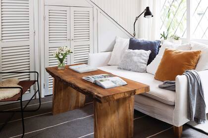 El ropero bajo la escalera se aprovechó para ocultar el sector de lavadero. Lámpara de brazo móvil pintada de negro mate (Beltrame). Alfombra lavable (Rugit).