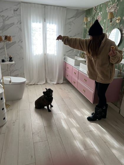 El rosa, también presente en la bañera, y los tonos claros predominan en el baño