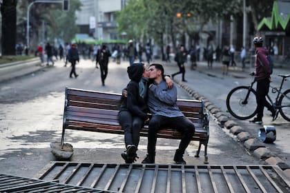 Sábado 19 de octubre. Una pareja se besa en un banco que fue usado como barricada