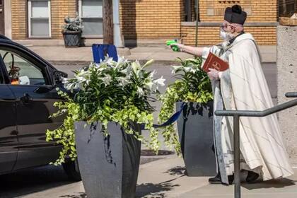 El sacerdote Tim Pelc, con la biblia en mano, bendijo "a distancia" a todos los que pudo