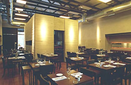 El salón comedor, ambientado en tonos de madera oscura, con piso de lapacho y paredes texturadas