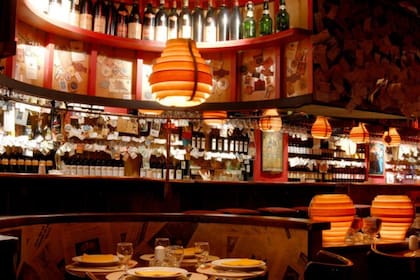 El salón con mesas y al fondo, la barra