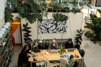 El salón principal, rodeado de vegetación y luz natural, dispone de mesas comunitarias, cubículos individuales y salas privadas.