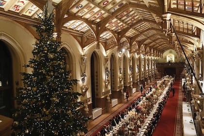 El salón St Georges’s Hall de Windsor, con el enorme abeto de 20 metros de altura y la mesa de 45 metros de largo, decorada con 158 velas y flores rojas recogidas de los propios jardines del castillo. Se dispuso un servicio de para 152 comensales, no para los 160 habituales, porque fue necesario hacer espacio para la decoración navideña