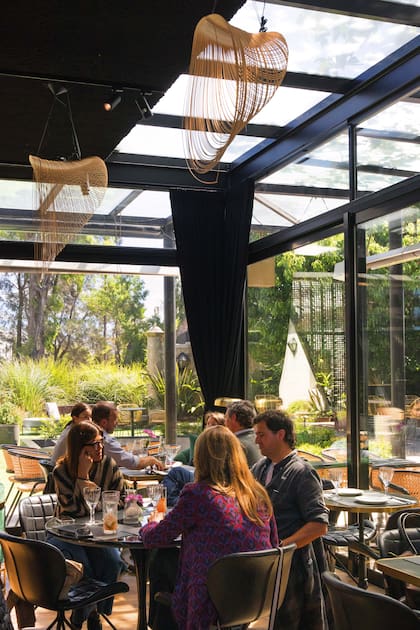 El salón tiene grandes ventanales a los jardines de Carrasco