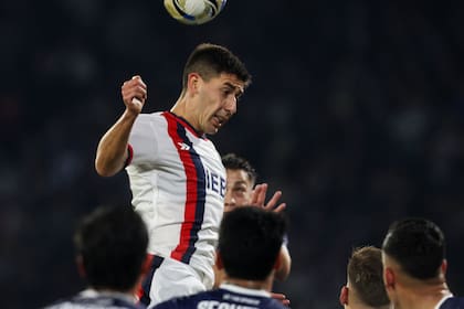 El salto de Gastón Hernández, de San Lorenzo, en medio de los jugadores de Talleres; el capitán forzó el gol de la victoria