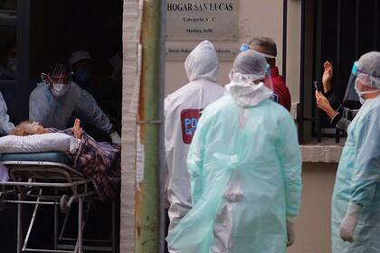 El saludo a la distancia entre una mujer que es trasladada y su familiar