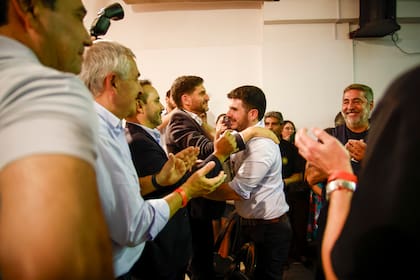 El saludo entre Maximiliano Pullaro y Leonel Chiarella, flamante titular de la UCR; aplaude a un costado, Daniel Angelici