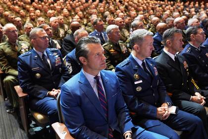 El secretario de Defensa Pete Hegseth (al centro), sentado junto al jefe del Estado Mayor Conjunto, general de la Fuerza Aérea Dan Caine (tercero desde la derecha), y altos mandos militares estadounidenses, escuchan el discurso del presidente Donald Trump en la Base del Cuerpo de Infantería de Marina de Quantico