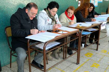 El senador nacional Luis Juez (iz), trabajando como fiscal de mesa