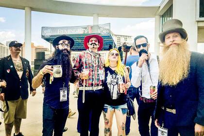 El señor de galera y pelos colorados se llama Scot Metts llegó desde Orlando. Es Campeón Mundial de Barba y Estilo de Bigote y acá posa contento con varios amigos.