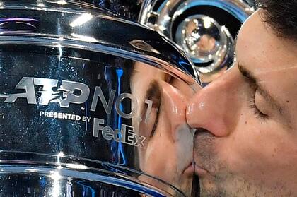 El serbio Novak Djokovic celebra con el trofeo de jugador número 1 de la ATP después de vencer al noruego Casper Ruud durante su único partido de la primera ronda de las Finales ATP en el Pala Alpitour de Turín el 15 de noviembre de 2021 (Foto de Marco BERTORELLO / AFP).